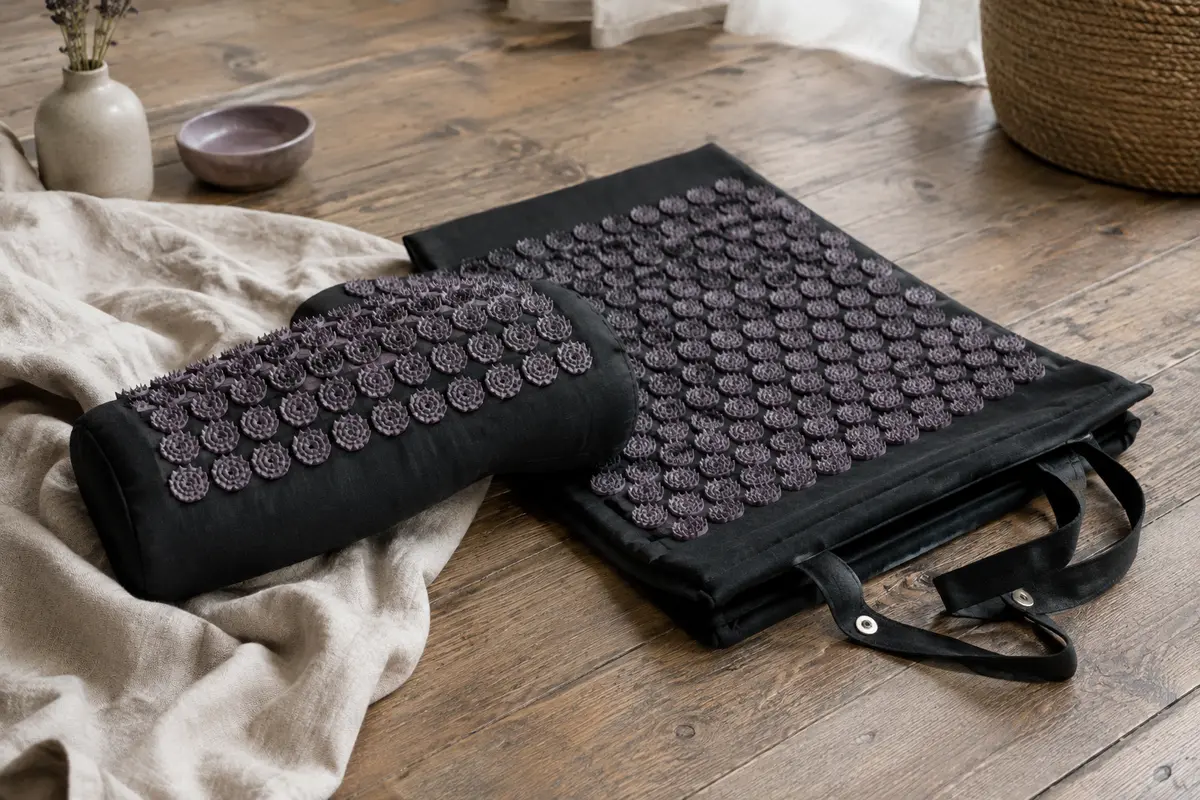 Tapis d’acupression noir pliable avec coussin assorti et poignées à pressions dans un intérieur calme