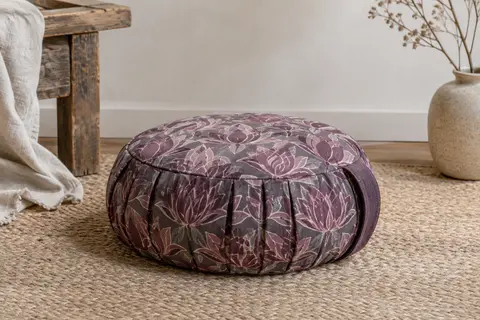Coussin de méditation Zafu plissé à motifs de lotus, posé sur un tapis dans un intérieur calme