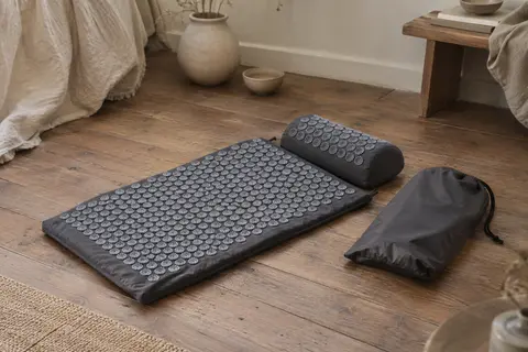 Tapis et coussin d’acupression gris ardoise avec leurs pointes en plastique et un sac en nylon.