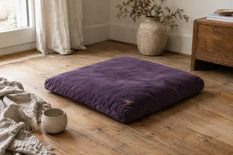 Tapis de méditation Zabuton violet en velours de coton posé sur un parquet dans un intérieur apaisant.