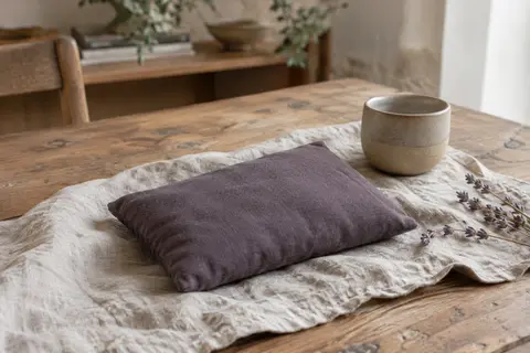 Bouillotte sèche Sakito en polycoton posée sur du lin froissé dans un intérieur calme